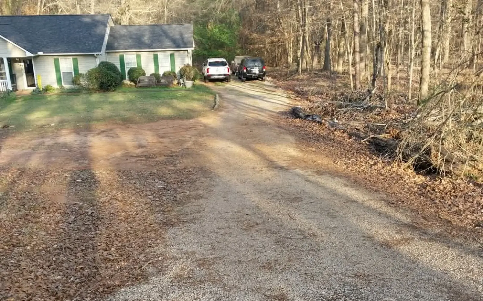 Before: rutted gravel and dirt driveway in front of the same house