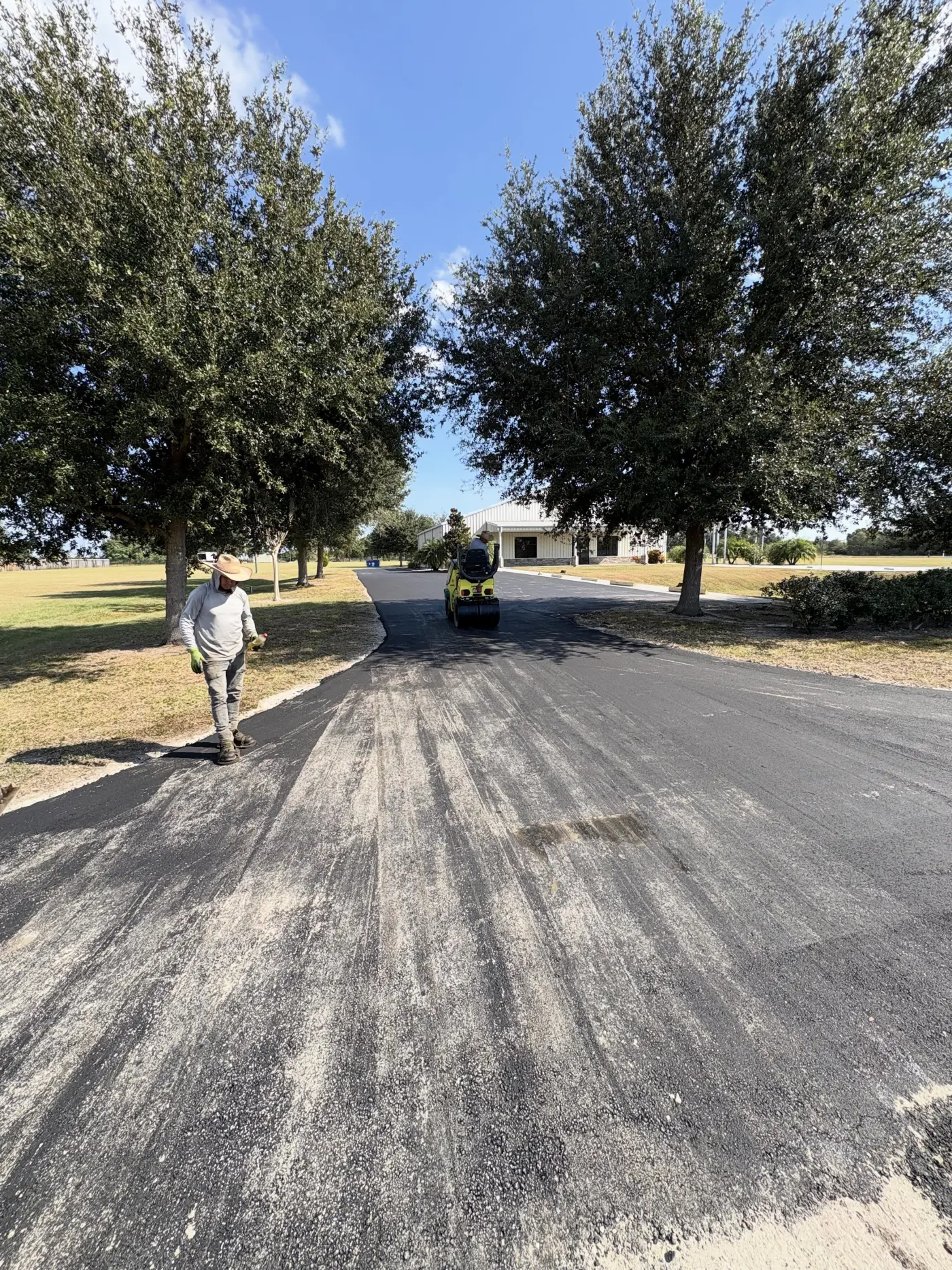 Long curving freshly paved driveway leading toward a Georgia home